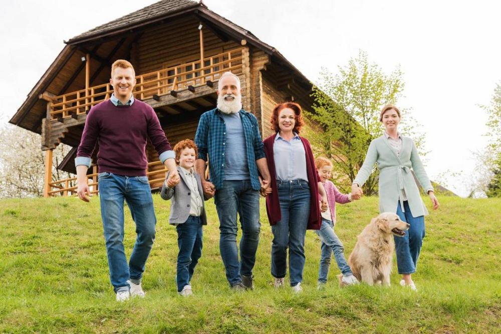 multigenerational family walking outside their cabin with a dog