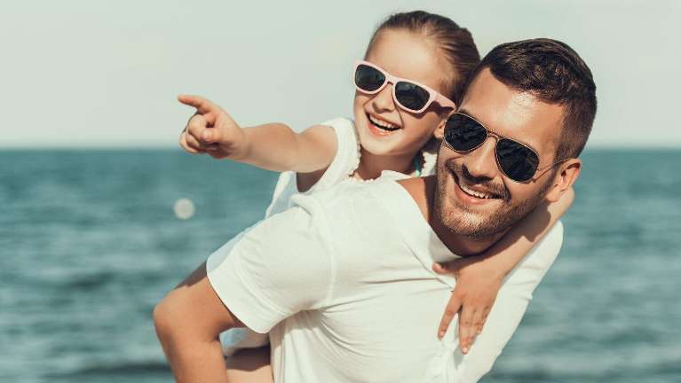 young girl and her dad smiling while wearing sunglasses 