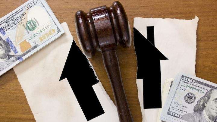 gavel sitting on top of ripped paper with cash beside it
