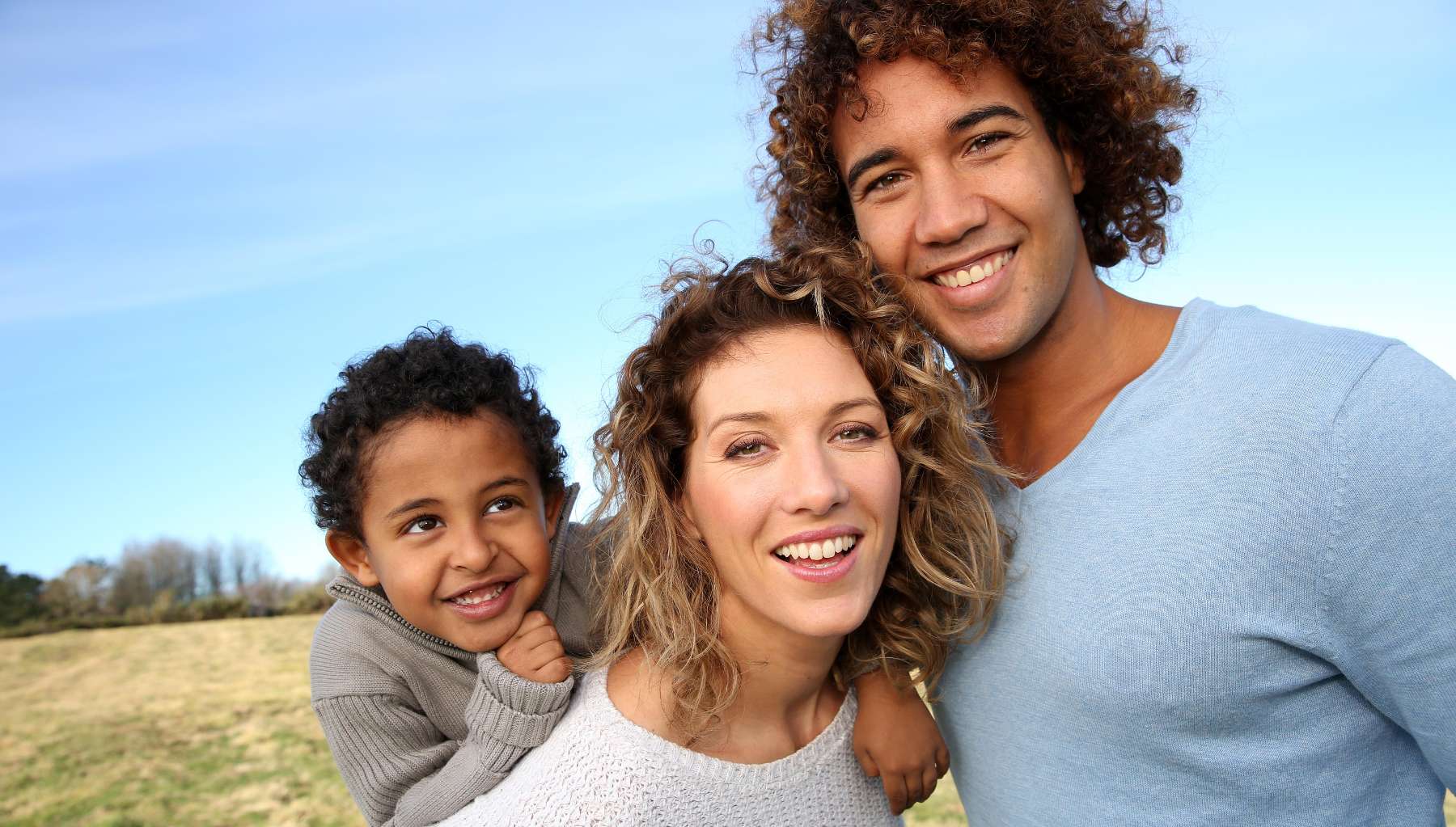 mother, father, and child smiling in a schaumburg park