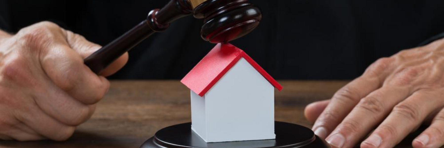 gavel coming down on toy house